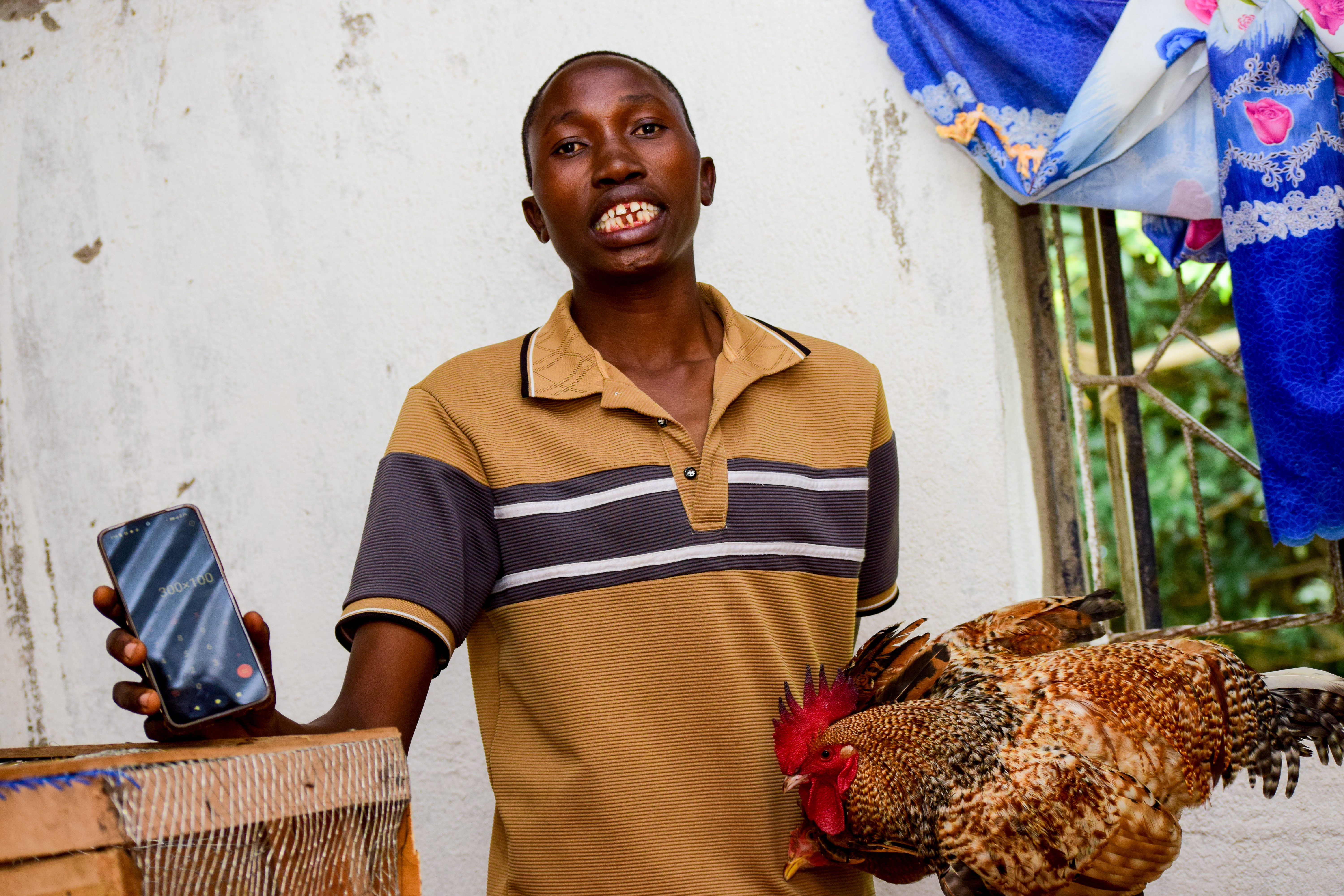 William Otwane with his poultry in Angurai East Ward, Busia County
